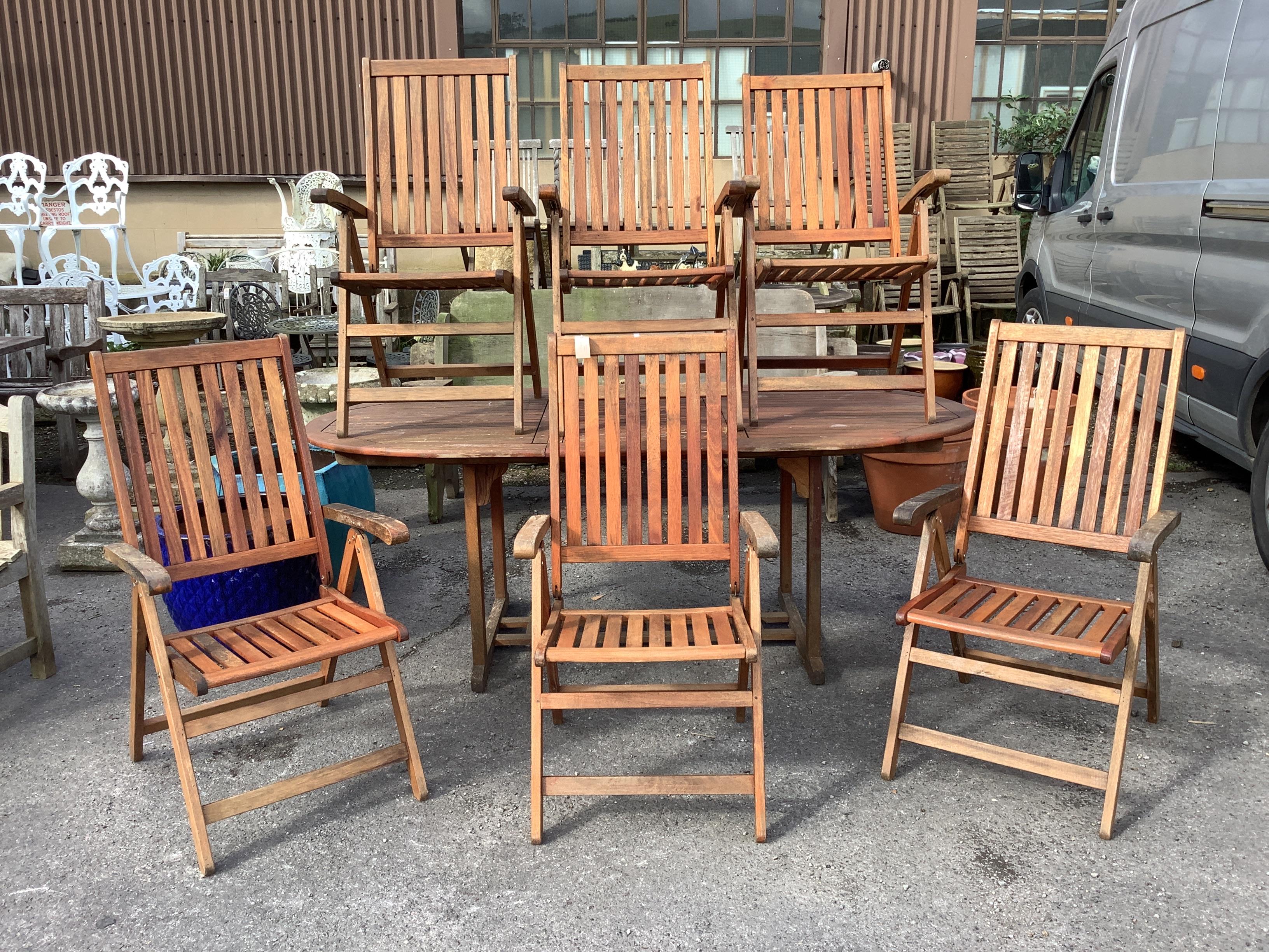 A Deuba Furniture stained teak extending garden table, 200cm extended, depth 100cm, height 74cm and six folding armchairs with cushions